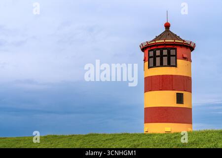 Ein minimalistischer Blick auf den ikonischen Leuchtturm Pilsum an der Wattenmeerküste Norddeutschlands Stockfoto