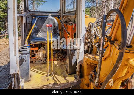 9. August 2025, Kopaonik, Serbien: Innenraum der Baggerkabine mit schwarzem Sitz, Steuerhebel und Hydraulikschläuchen auf einer Baustelle Stockfoto