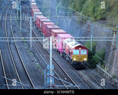 DB Cargo Class 66 66152 fährt im September 2025 einen Containerzug durch Northamptonshire Stockfoto