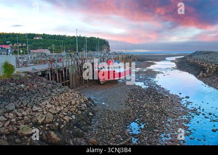 Ein Fischerboot bei Ebbe auf Grund im Hafen von Alma New Brunswick am Rande des Fundy-Nationalparks Stockfoto