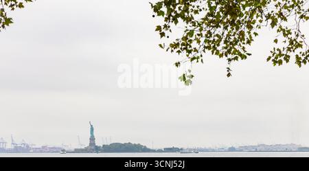 Malerischer Blick auf die Freiheitsstatue und Staten Island vom Battery Park in New York an einem regnerischen Tag Stockfoto