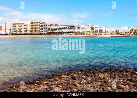 Lanzarote Hauptstadt Strand, Playa del Reducto, Arrecife. Goldener Sand, ruhiges türkisfarbenes Wasser und urbaner Charme unter sonnigem Himmel. Ideal für Reisen und Tourismus Stockfoto