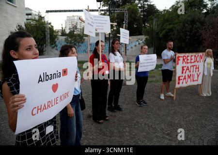 Charlie Kirk Gedenkfeier in Tirana, Albanien am 21. September 2025. Die Menschen halten Plakate, während sie am 21. September 2025 an einer Gedenkfeier des konservativen politischen Aktivisten Charlie Kirk auf dem Platz der Mutter Teresa in Tirana, Albanien, teilnehmen. Kirk wurde am 10. September während einer Pause auf seiner American Comeback Tour erschossen, die von Turning Point USA an der Utah Valley University organisiert wurde. TIRANE ALBANIEN Copyright: XMALTONxDIBRAx Stockfoto