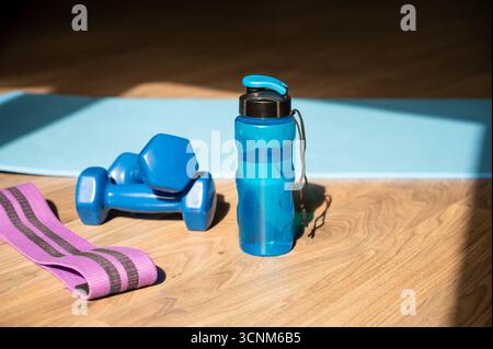Hanteln Widerstandsband und Wasserflasche auf Yogamatte auf dem Boden zu Hause platziert, Konzept des Fitness-Trainings und gesunden Lebensstil Stockfoto