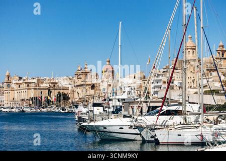 Birgu, Malta – 11. April 2025: Panoramablick vom Yachthafen von Birgu aus auf die historische Uferpromenade von Senglea mit Kirchen, Kuppeln, berühmten Türmen, A Stockfoto