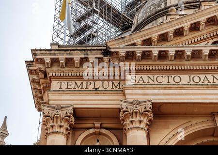 Gozo, Malta – 12. April 2025: Nahaufnahme der lateinischen Inschrift und kunstvoller architektonischer Details an der Fassade der Rotunde von St. Johannes dem Täufer Stockfoto