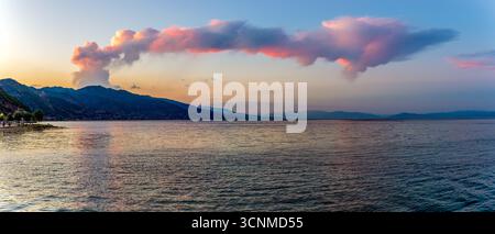 Goldener Sonnenuntergang über dem See Ohrid in Pogradec, Albanien – Ein atemberaubendes Panorama aus ruhigen Gewässern, pulsierendem Himmel und majestätischen Bergsilhouetten Stockfoto