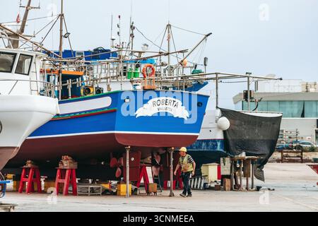 Marsaxlokk, Malta - 13. April 2025: Fischerboote auf dem Trockendock werden gewartet, darunter das hellblaue Schiff Roberta Valletta, an der Schifffahrt Stockfoto