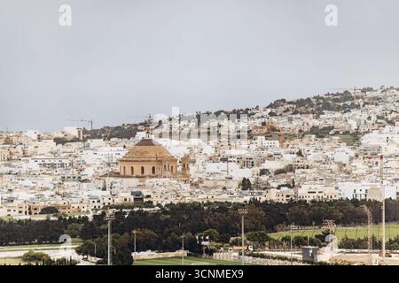 Fernblick von Mdina über das Stadtbild von Mosta, mit der berühmten Rotunde von Mosta, die sich deutlich über den weißen Gebäuden erhebt. Stockfoto