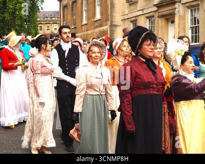 Menschen, die in Regentschaftskostümen gekleidet sind, nehmen an einer Promenade durch die Straßen von Bath bei der Jane Austen Festival Parade 2025 teil. Stockfoto