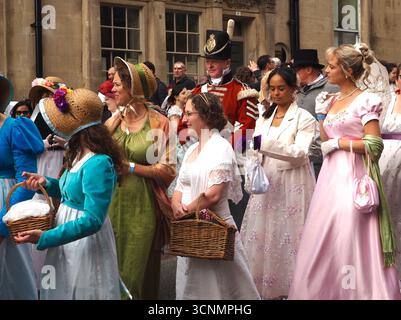 Menschen, die in Regentschaftskostümen gekleidet sind, nehmen an einer Promenade durch die Straßen von Bath bei der Jane Austen Festival Parade 2025 teil. Stockfoto