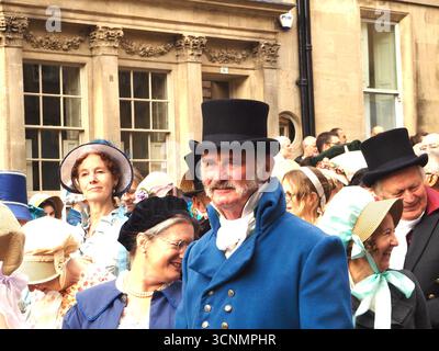 Menschen, die in Regentschaftskostümen gekleidet sind, nehmen an einer Promenade durch die Straßen von Bath bei der Jane Austen Festival Parade 2025 teil. Stockfoto