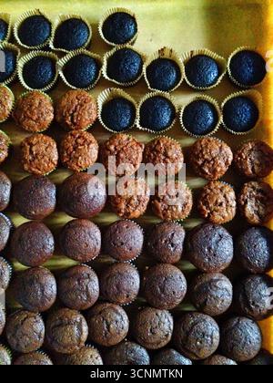 Viele Schokoladen- und Karotten-Cupcakes auf einem Tablett sind glutenfrei. Stockfoto