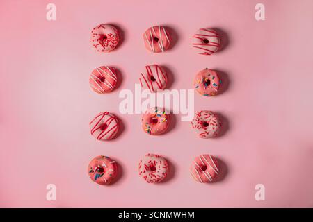 Flacher Lay von Pink Donuts auf rosa Hintergrund Stockfoto
