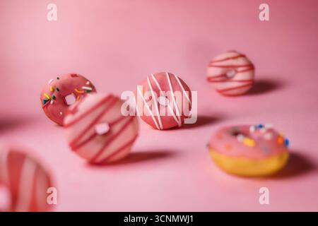 Sammlung von rosa Donuts, die auf rosa Tisch sitzen Stockfoto