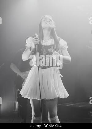 Sänger, der während des Konzerts in traditionellem Outfit auf der Bühne auftritt Stockfoto