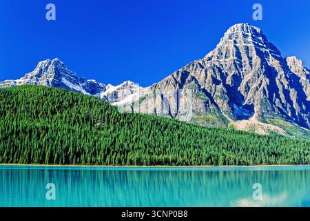 Waldsee mit türkisfarbenem Gletscherwasser an einem hohen Berggipfel in herrlicher Sonne Stockfoto