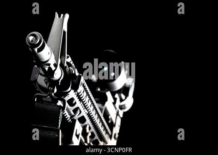 Ein AR-15-Gewehr wird in scharfen Details aufgenommen und in einem Studio vor tiefschwarzem Hintergrund fotografiert, dessen schlanke Linien und Metallic-Oberfläche hervorgehoben sind Stockfoto
