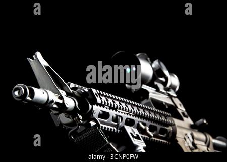 Ein AR-15-Gewehr wird in scharfen Details aufgenommen und in einem Studio vor tiefschwarzem Hintergrund fotografiert, dessen schlanke Linien und Metallic-Oberfläche hervorgehoben sind Stockfoto