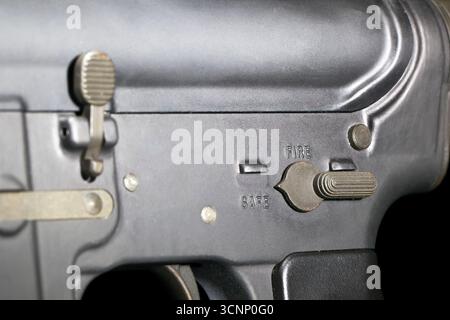 Ein AR-15-Gewehr wird in scharfen Details aufgenommen und in einem Studio vor tiefschwarzem Hintergrund fotografiert, dessen schlanke Linien und Metallic-Oberfläche hervorgehoben sind Stockfoto