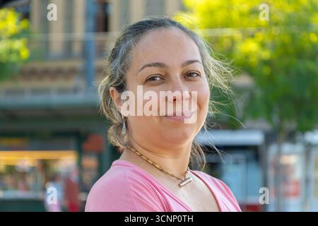 Straßenporträt einer dunkelhaarigen Frau im Alter von 40-45 Jahren auf dem Hintergrund einer Stadtstraße Stockfoto