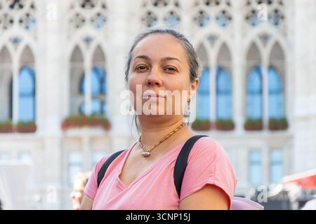Porträt einer Frau mittleren Alters auf einem Stadtplatz an einem sonnigen Tag Stockfoto