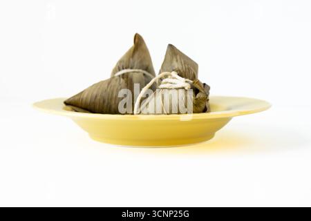 Zongzi auf einem gelben Teller - West Lake in Huizhou, Provinz Guangdong, China, ist eine Touristenattraktion mit antiker Architektur Stockfoto