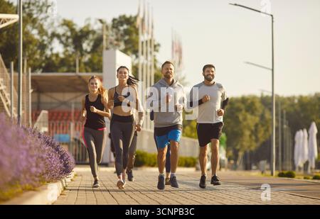 Gruppe junger und sportlicher Männer und Frauen, die draußen joggen Stockfoto