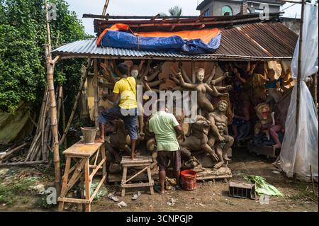 9/21/2025 Handwerker arbeiten an den letzten Schliffen, malen Ton-Idole der hinduistischen Göttin Durga in einer Werkstatt in der Töpferkolonie zu Zeiten von Mahalaya, einer der wichtigsten Regionen im Bezirk Nadia, wo die größte Anzahl von Ton-Idolen produziert wird, vor dem Durga Puja Festival in Tehatta, Westbengalen. Auf Mahalaya zeigt das Ritual von Chokkhu Daan (Augenspenden) Götzenmacher die Augen der Göttin Durga, eine heilige Handlung, die das Götzenbild zum Leben erweckt und das spirituelle Erwachen der göttlichen Form markiert. (Foto: Soumyabrata Roy/Pacific Press/SIPA USA) Stockfoto