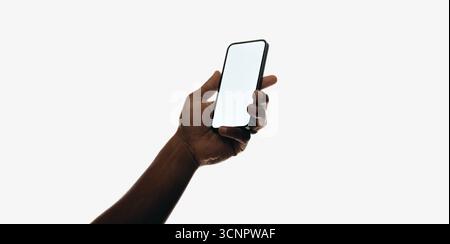 Nahaufnahme einer Hand, die ein Smartphone mit einem leeren weißen Bildschirm vor einem minimalistischen Hintergrund greift. Das Bild konzentriert sich auf Technologie und Interaktivität Stockfoto