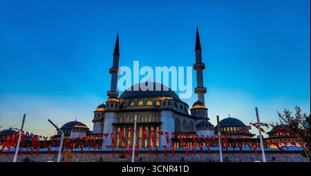 Kizilay Moschee in Ankara beleuchtet in der Abenddämmerung mit türkischen Fahnen Stockfoto