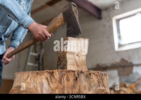 Deutschland - 21. September 2025: Ein Mann, der Holz hackt. Holz mit einer Axt zu Spalten, kann gefährlich sein. Das Bild zeigt die Unfallgefahr beim Hacken von Holz durch scharfe Werkzeuge, schwere Holzstücke und unachtsame Arbeit. *** Ein man beim Holzhacken. Beim Spalten von Holz mit der Axt entstehen Gefahren. Das Bild verdeutlicht die Unfallgefahr beim Holzhacken durch scharfe Werkzeuge, schwere Holzstücke und unachtsames Arbeiten. Stockfoto