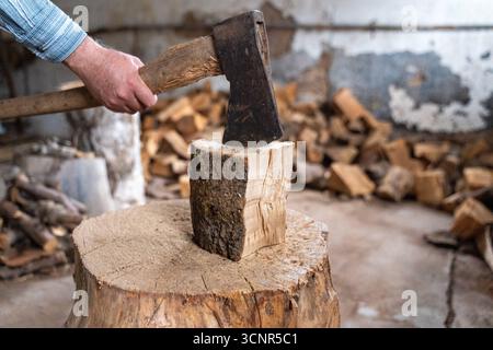 Deutschland - 21. September 2025: Ein Mann spaltet ein Stück Holz mit einer Axt. Das Bild repräsentiert Brennholz, Winterversorgung und traditionelle Energieversorgung durch Holz, das als nachhaltige Wärmequelle für den Winter genutzt wird. *** Ein Mann spaltet mit einer Axt ein Holzstück. Das Bild steht für Brennholz, Wintervorrat und traditionelle Energieversorgung durch Holz, das als nachhaltige Wärmequelle für den Winter genutzt wird. Stockfoto