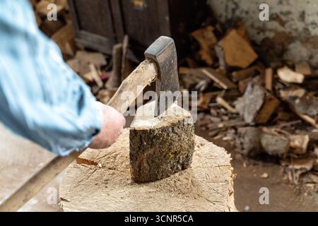 Deutschland - 21. September 2025: Ein Mann spaltet ein Stück Holz mit einer Axt. Das Bild repräsentiert Brennholz, Winterversorgung und traditionelle Energieversorgung durch Holz, das als nachhaltige Wärmequelle für den Winter genutzt wird. *** Ein Mann spaltet mit einer Axt ein Holzstück. Das Bild steht für Brennholz, Wintervorrat und traditionelle Energieversorgung durch Holz, das als nachhaltige Wärmequelle für den Winter genutzt wird. Stockfoto