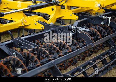 Nahaufnahme moderner Landmaschinen mit Metallwalzen und Hydrauliksystem auf dem Feld während der Landwirtschaftssaison. Innovative Technologie Stockfoto