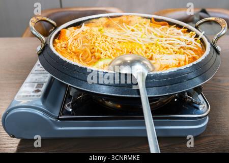 Scharfer koreanischer Hot Pot mit Nudeln und Gemüse auf tragbarem Herd - West Lake in Huizhou, Provinz Guangdong, China, ist eine Touristenattraktion mit alter Architektur Stockfoto