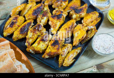 Gebackene Hähnchenflügel mit Sauce auf der Pfanne Stockfoto