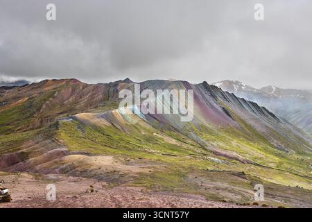 Der Palccoyo Rainbow Mountain entfaltet sich in atemberaubenden Farbschichten, einem versteckten Juwel in den peruanischen Anden. Im Gegensatz zu seinen berühmten Geschwistern, dieses heitere Wunder Stockfoto