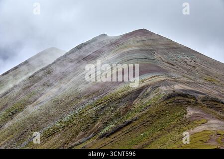 Der Palccoyo Rainbow Mountain entfaltet sich in atemberaubenden Farbschichten, einem versteckten Juwel in den peruanischen Anden. Im Gegensatz zu seinen berühmten Geschwistern, dieses heitere Wunder Stockfoto