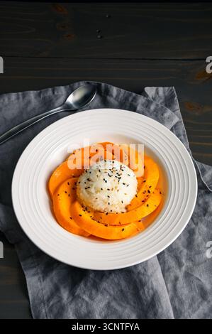 Mango Sticky Reis mit Kokosnusssauce in einer flachen Schüssel angewinkelter Blick: Thailändisches Dessert mit klebrigem Reis, frischem Obst und gerösteten Sesamsamen Stockfoto
