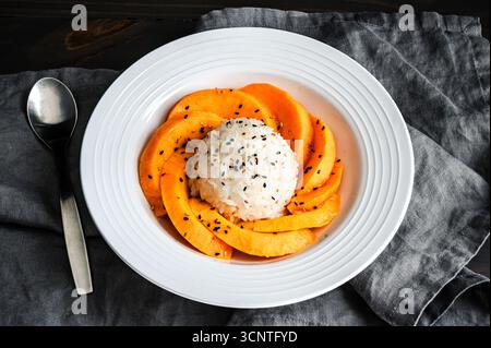 Mango Sticky Reis mit Kokosnusssauce in einer flachen Schüssel angewinkelter Blick: Thailändisches Dessert mit klebrigem Reis, frischem Obst und gerösteten Sesamsamen Stockfoto
