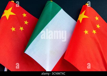 Die italienische Nationalflagge auf dem Flaggenmast zwischen der chinesischen Nationalflagge. Ein Konzept der Beziehungen zwischen Italien und China. Stockfoto
