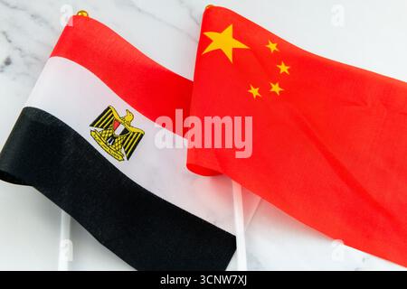 Die ägyptische Nationalflagge auf dem Fahnenmast neben der chinesischen Nationalflagge. Ein Konzept der Beziehungen zwischen Ägypten und China. Stockfoto