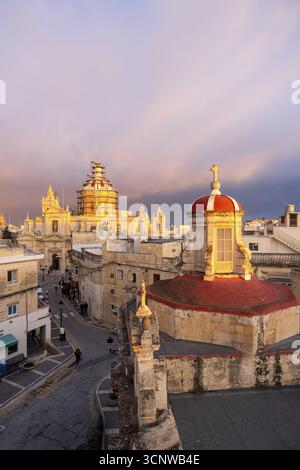 Skyline von Rabat mit der St. Paul Kirche Kuppel auf der linken Seite bei Sonnenuntergang, Rabat Mdina, Malta Stockfoto