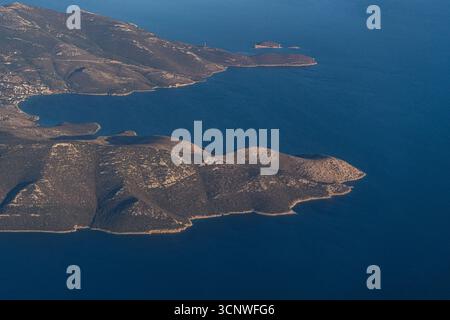 Ein atemberaubender Blick aus der Vogelperspektive auf Griechenlands atemberaubende Küste aus dem Flugzeug und die majestätische Mischung aus blauem Meer und rauem Gelände in einem Stockfoto