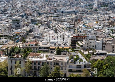 Aus der Vogelperspektive von Athen mit einer dichten Stadtlandschaft mit weißen Gebäuden, üppigem Grün und vielfältiger Architektur. Die lebendigen Details spiegeln die Stadt wider Stockfoto