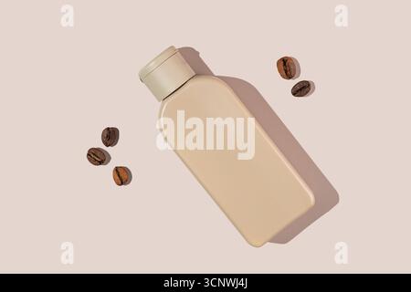 Eine elegante beige Kosmetikflasche mit Koffein und verstreuten Kaffeebohnen auf hellem Hintergrund. Ideal für Schönheit und Hautpflege Stockfoto