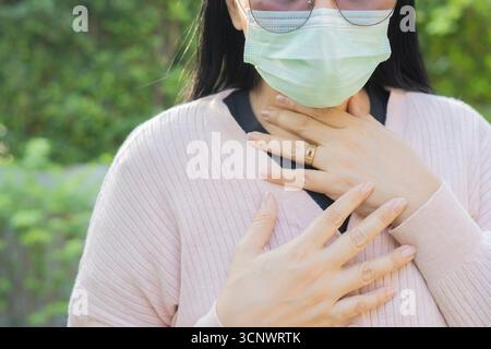 Virus Atembeschwerden Frau mit Hustenatmungsproblem. Asiatische Frau in Schmerzen berührende Brust Atembeschwerden Fieber, Husten, Körperschmerzen. Stockfoto