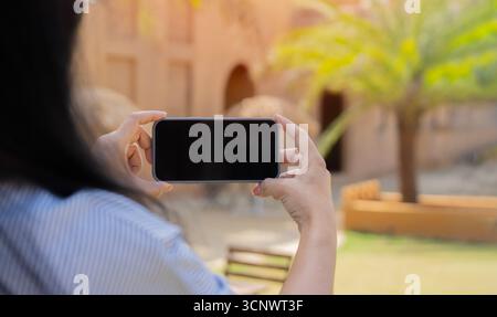 Nahaufnahme der Hände einer Frau, die ihr Mobiltelefon in der Hand hält und Fotos macht, um sie mit Freunden in sozialen Medien zu teilen Stockfoto