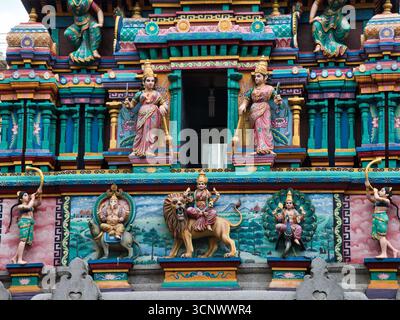 Komplizierte Skulpturen an einer Hindutempelfassade - Eine lebendige und detaillierte Nahaufnahme der kunstvollen Skulpturen und dekorativen Figuren an der Außenseite eines H Stockfoto